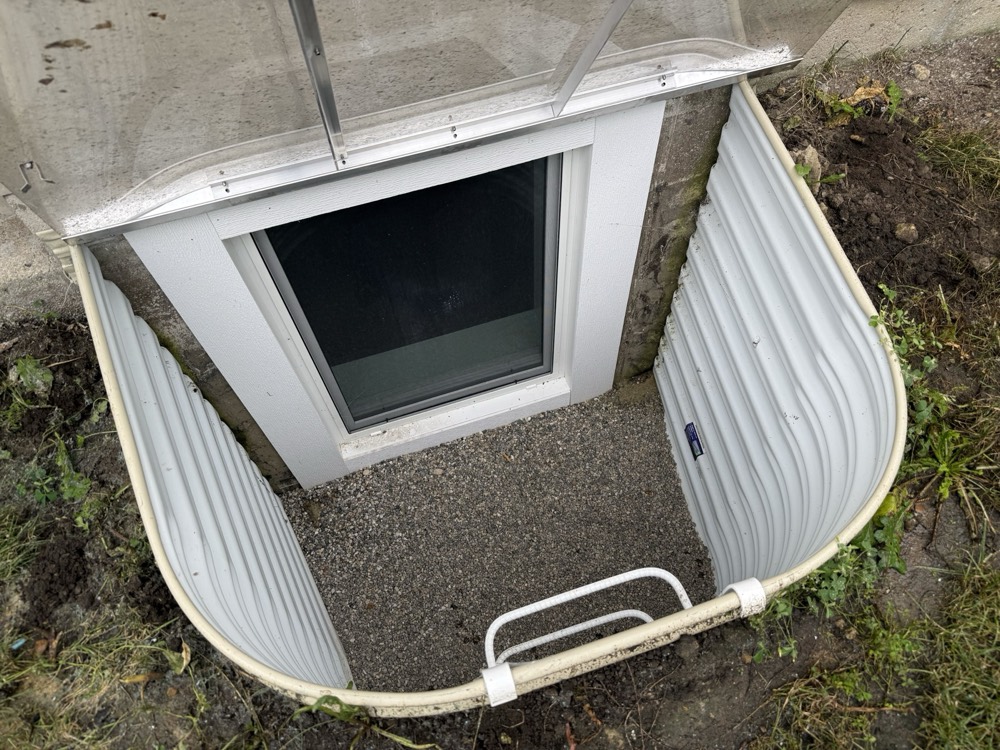 Finished basement egress window and window well with gravel base and ladder